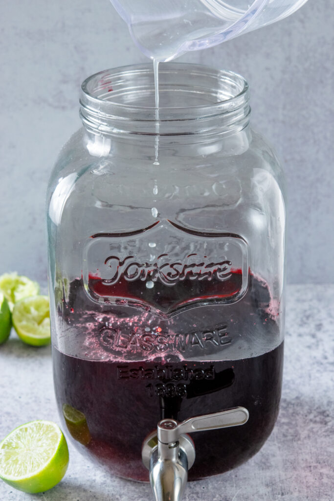 Add fresh lime juice to the hibiscus tea and simple syrup mixture.