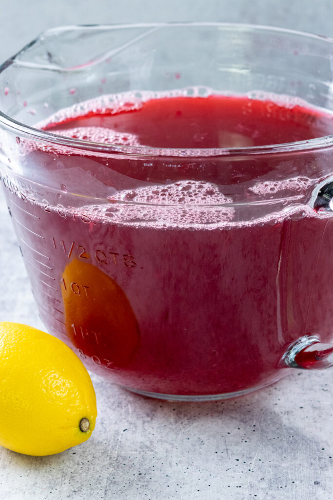 Two quarts of homemade hibiscus lemonade ready to be chilled and served over ice.