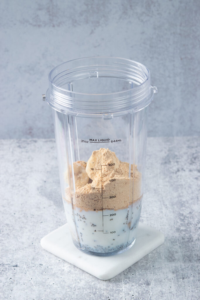 Powdered peanut butter added to blender cup to make a smoothie.