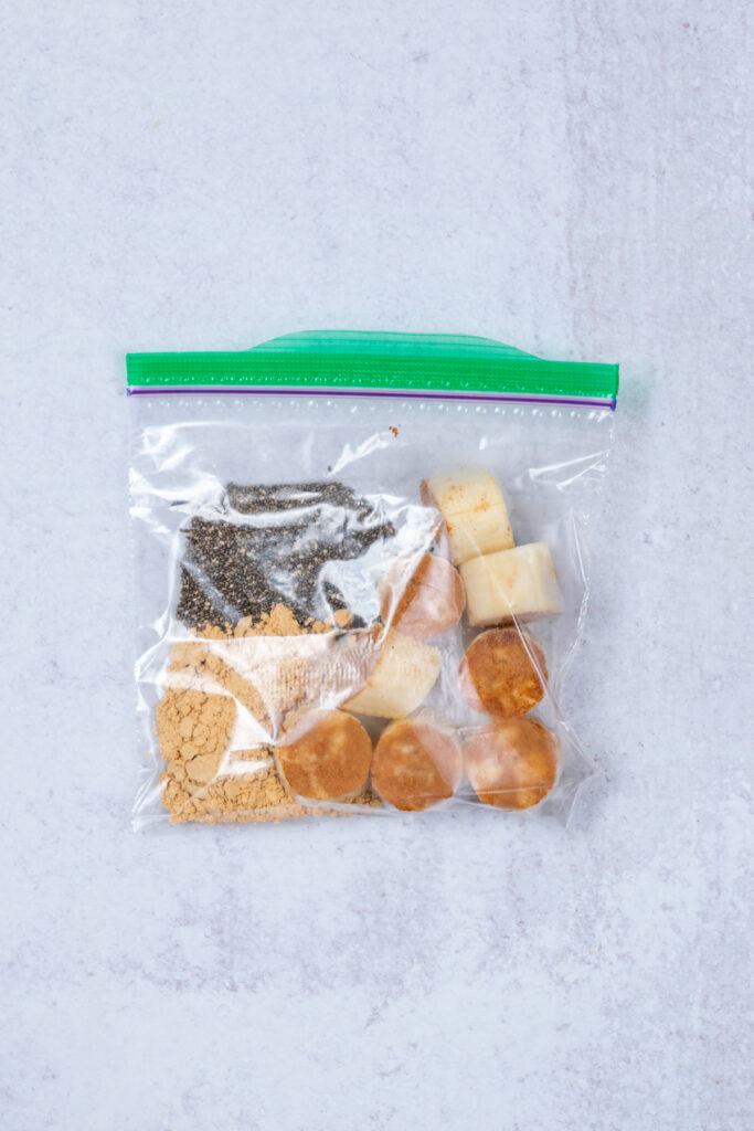 A homemade smoothie freezer pack with pieces of frozen banana dipped in powdered peanut butter,