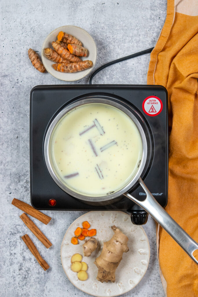 Steeping golden milk in a saucepan on the stove.