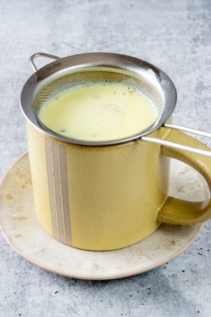 The strainer is still in the yellow mug that's full of the golden turmeric latte.