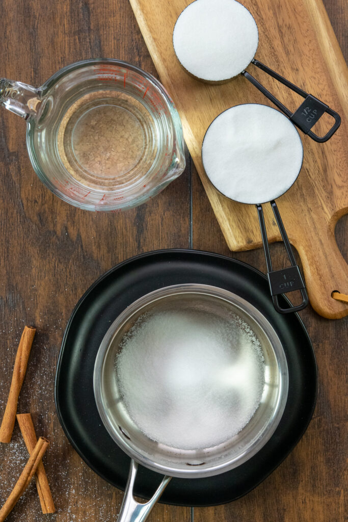 A saucepan with sugar in it to make a simple syrup base for the homemade pumpkin spice syrup.