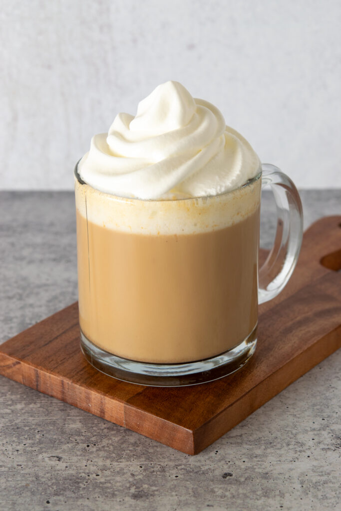 A big swirl of whipped cream on top of the pumpkin spice latte.