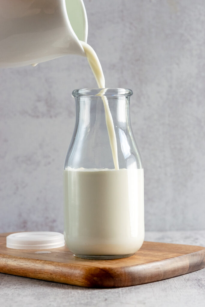 Adding milk to the bottle with cream.