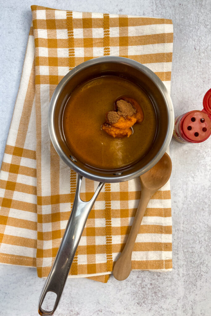 Pumpkin puree and spices added to simple syrup in the saucepan.
