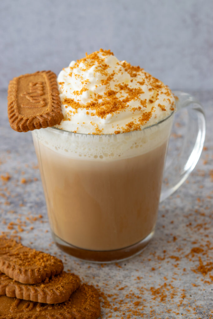 Homemade cookie butter latte with a Biscoff cookie sitting on the edge of the mug.