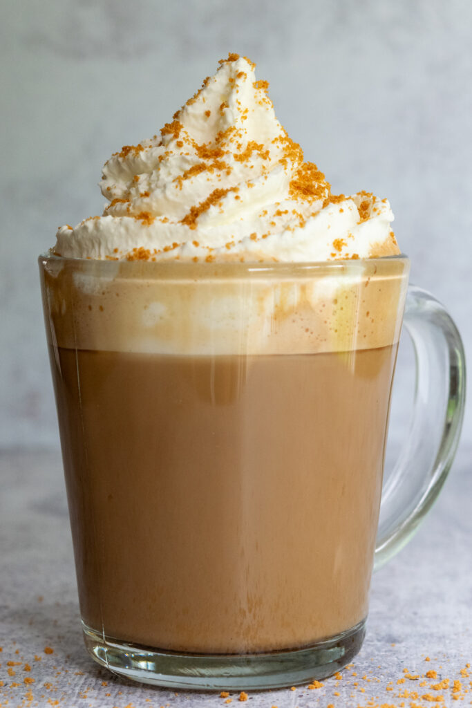 A homemade cookie butter latte topped with whipped cream and Biscoff cookie crumble.