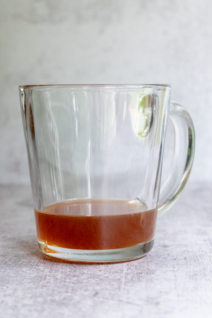 A mug with some cookie butter syrup in the bottom to make a cookie butter latte.