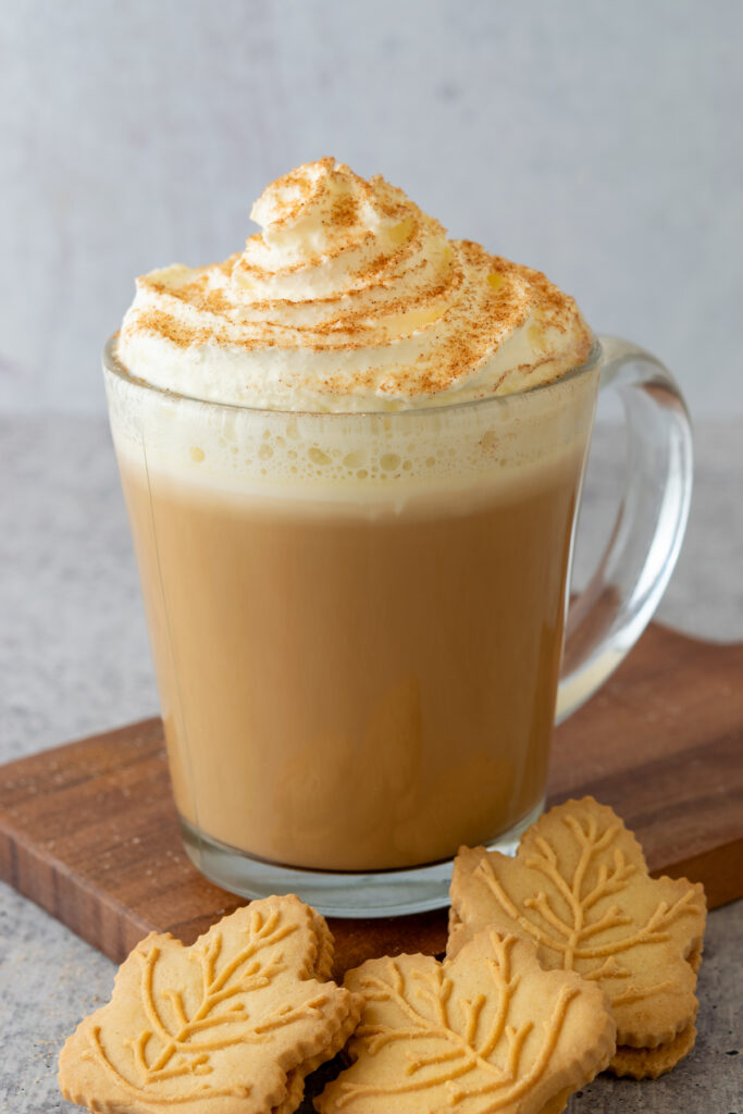 A maple latte and three maple leaf shaped maple syrup cookies.
