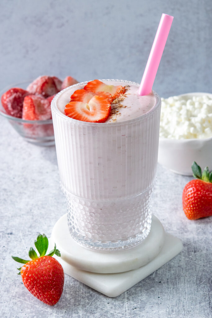 A creamy strawberry cottage cheese smoothie that's garnished with strawberry slices and a sprinkle of flaxseed meal.